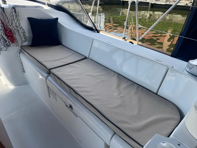 Slide: The Image of Beneteau Oceanis Clipper 473 cockpit with cushioned seating, 2005 model, docked by the water. - 18