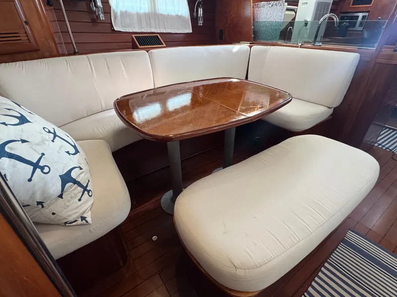 Slide: The Image of Interior of 2005 Beneteau Oceanis Clipper 473 with cozy seating and wooden table. - 3