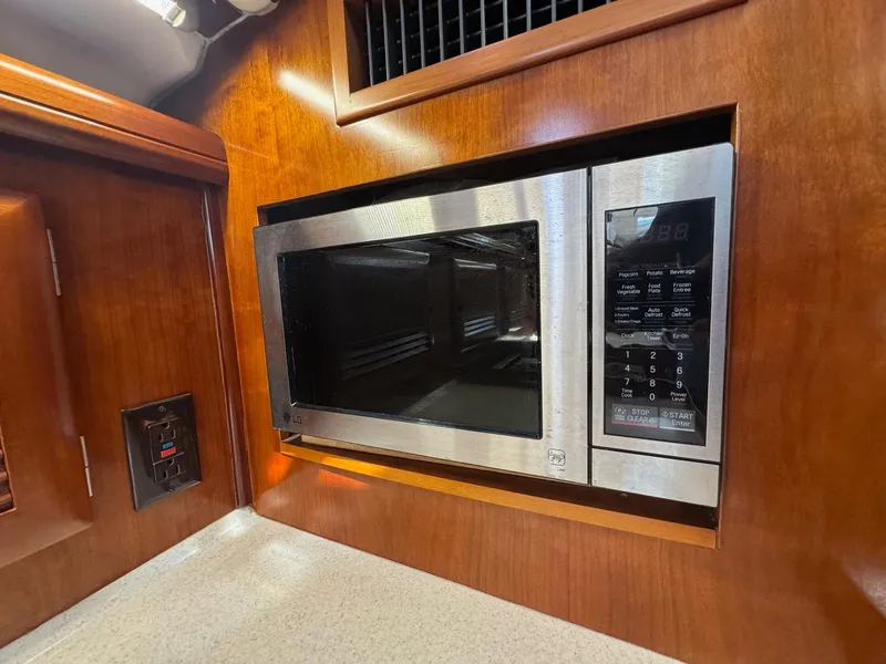Slide: The Image of Microwave in 2005 Beneteau Oceanis Clipper 473 yacht kitchen, set in wooden cabinetry. - 38