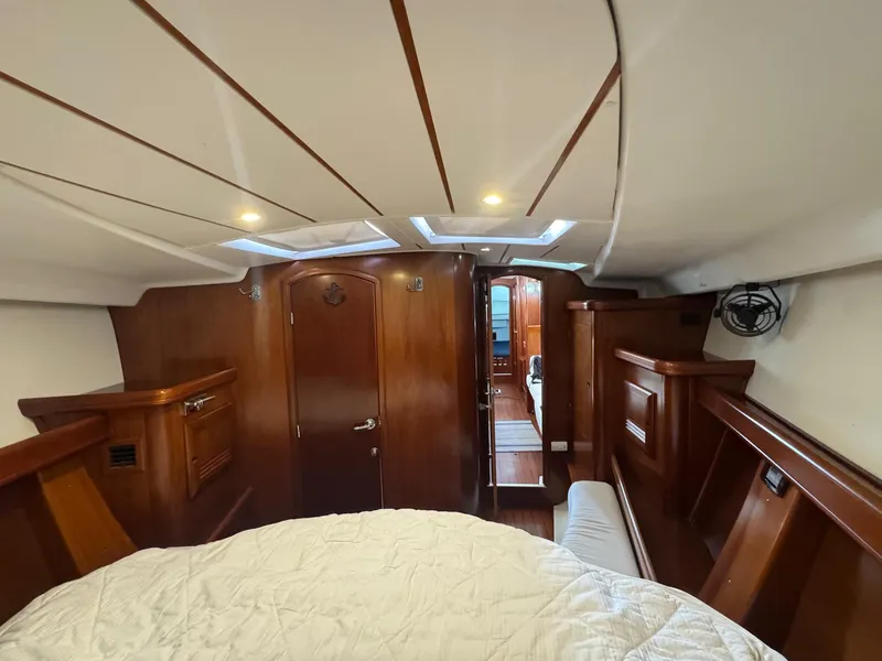 Slide: The Image of Interior of 2005 Beneteau Oceanis Clipper 473 yacht, featuring wood paneling and cozy cabin. - 42