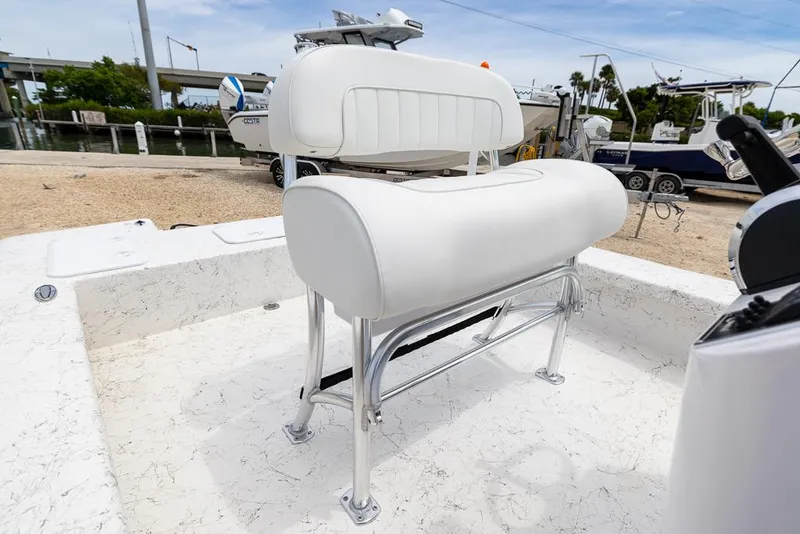 Slide: The Image of 2026 Coastal Skiff 231 boat with white cushioned seating and chrome frame. - 11