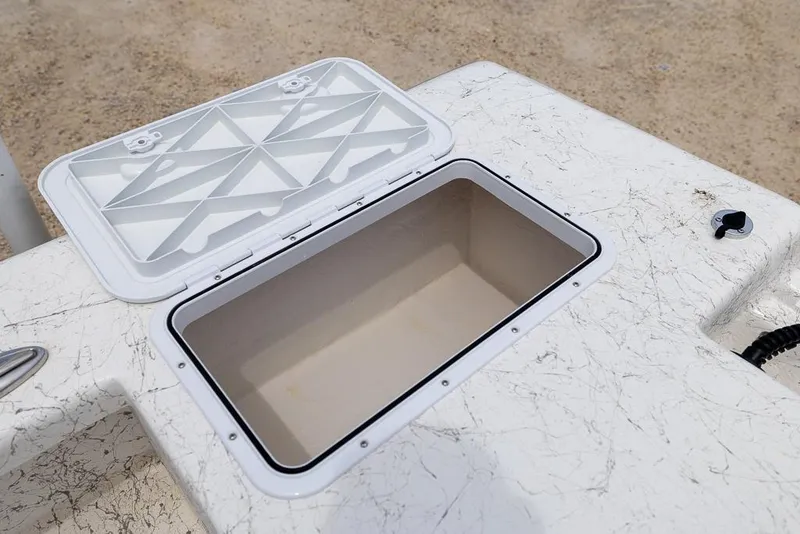 Slide: The Image of Open storage compartment on 2026 Coastal Skiff 231 boat, featuring a white textured surface. - 14