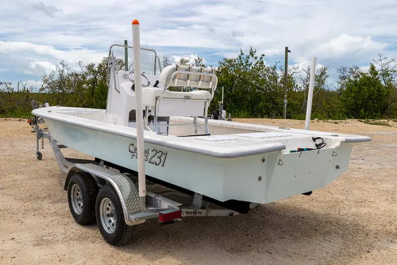 Slide: The Image of 2026 Coastal Skiff 231 boat on trailer, parked outdoors, ready for adventure. - 2