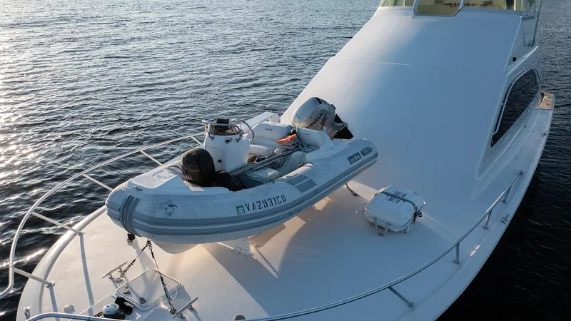 Slide: The Image of 2004 Ocean Yachts 57 Convertible with dinghy on deck, cruising on calm waters. - 11