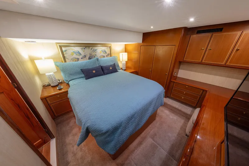 Slide: The Image of Luxurious bedroom interior of 2004 Ocean Yachts 57 Convertible, featuring elegant wood cabinetry and cozy bedding. - 21