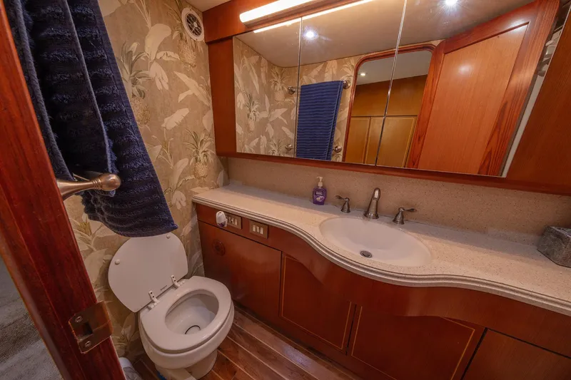 Slide: The Image of Luxurious bathroom in 2004 Ocean Yachts 57 Convertible, featuring elegant wood and floral wallpaper. - 25
