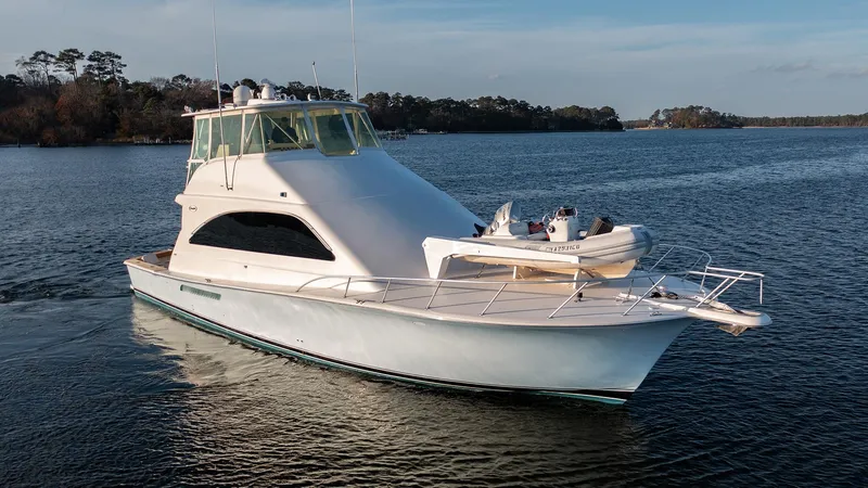 Slide: The Image of 2004 Ocean Yachts 57 Convertible cruising on a serene lake with lush forest backdrop. - 3