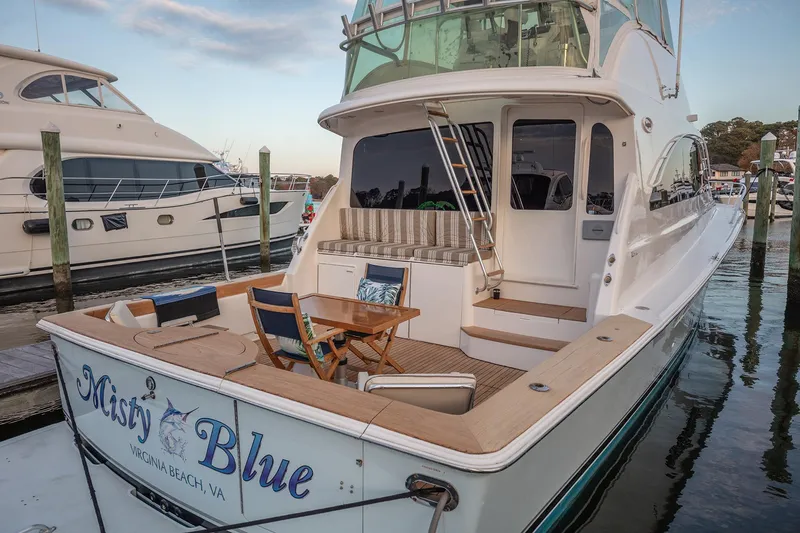 Slide: The Image of 2004 Ocean Yachts 57 Convertible docked, featuring spacious deck and elegant seating area. - 42