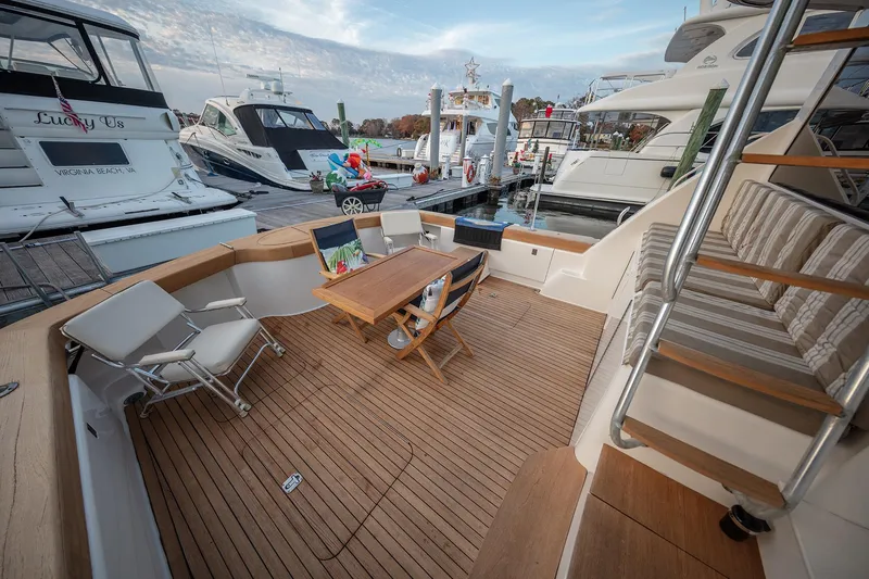 Slide: The Image of 2004 Ocean Yachts 57 Convertible yacht deck with seating and table at marina. - 43