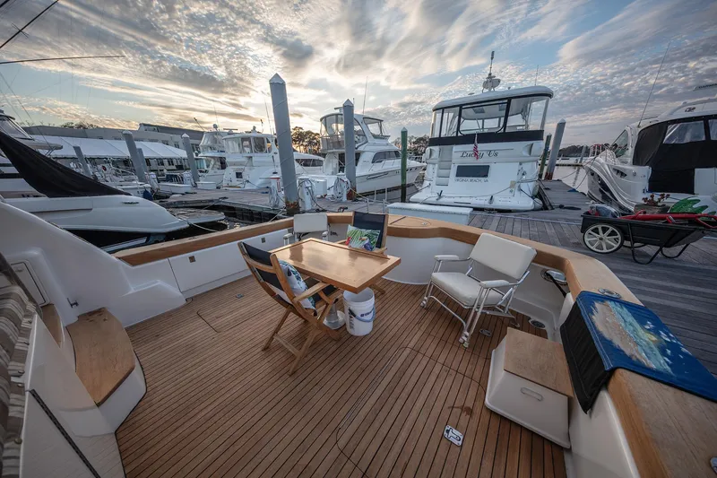 Slide: The Image of Luxurious 2004 Ocean Yachts 57 Convertible docked, featuring elegant teak deck and seating area. - 44