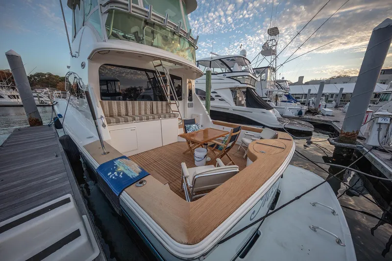 Slide: The Image of 2004 Ocean Yachts 57 Convertible docked at marina, featuring spacious deck and seating area. - 41