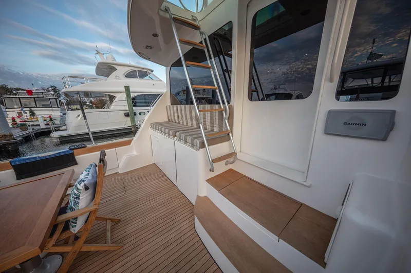 Slide: The Image of 2004 Ocean Yachts 57 Convertible yacht deck with seating and ladder, docked at marina. - 46