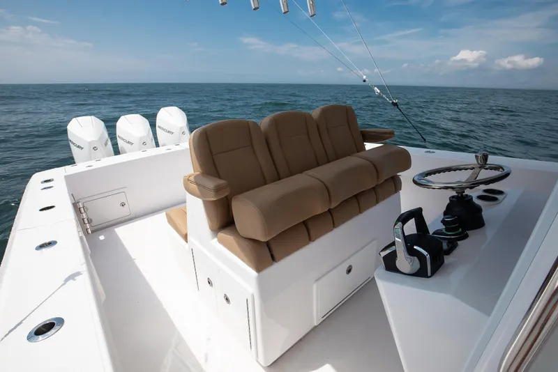 Slide: The Image of 2025 Bahama 37 Super Center Console boat with triple Mercury engines on open sea. - 13