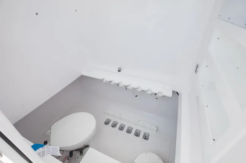 Slide: The Image of Interior of 2025 Bahama 37 Super Center Console boat, featuring a compact marine toilet. - 18
