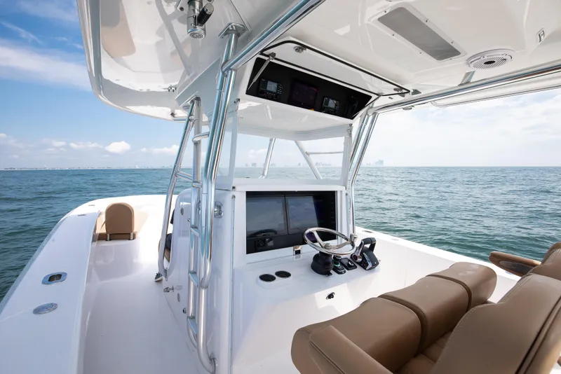 Slide: The Image of 2025 Bahama 37 Super Center Console boat on open water, featuring modern helm and seating. - 16
