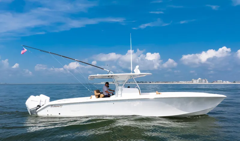 Slide: The Image of 2025 Bahama 37 Super Center Console boat cruising on open water under blue sky. - 7