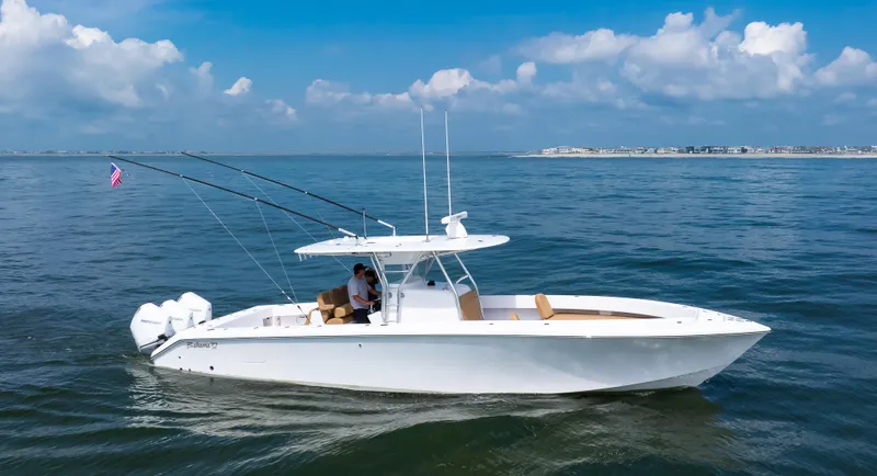 Slide: The Image of 2025 Bahama 37 Super Center Console boat cruising on open water under blue skies. - 8