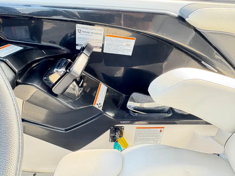 Slide: The Image of 2019 Yamaha Boats 242 Limited E-Series cockpit with steering and capacity label. - 14