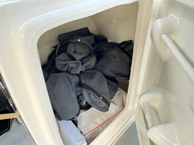 Slide: The Image of Storage compartment in 2019 Yamaha Boats 242 Limited E-Series filled with dark fabric items. - 17