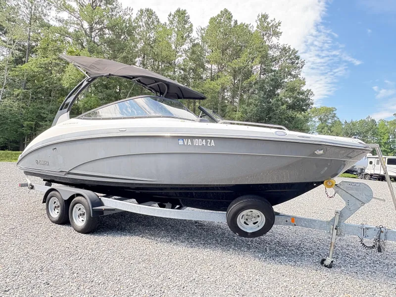 Slide: The Image of 2019 Yamaha Boats 242 Limited E-Series on trailer, parked outdoors with trees in background. - 4