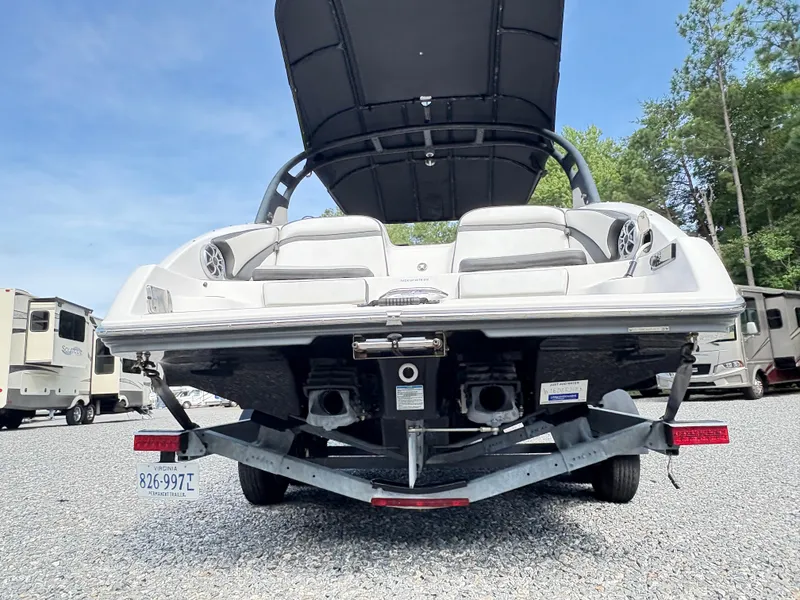 Slide: The Image of 2019 Yamaha Boats 242 Limited E-Series on trailer, rear view, parked outdoors. - 5
