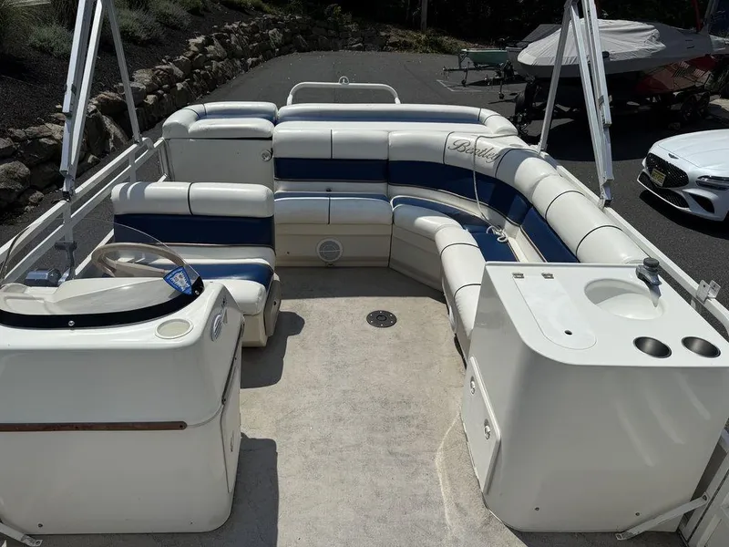 Slide: The Image of 2006 Bentley Pontoons 240 CRUISE interior with seating and helm, parked on pavement. - 13