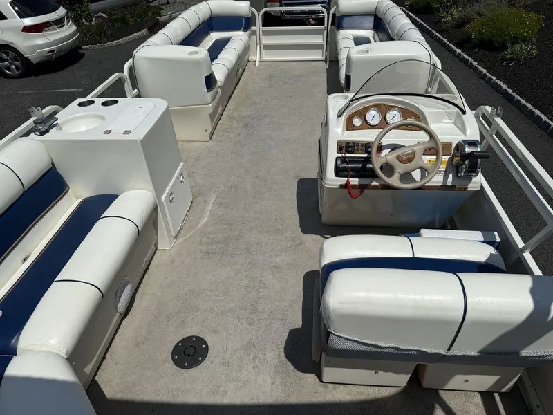 Slide: The Image of 2006 Bentley Pontoons 240 CRUISE interior with white and blue seating, steering console, and cup holders. - 9