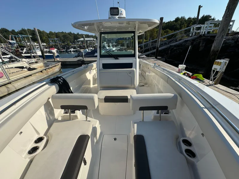Slide: The Image of 2023 Sailfish 312 CC boat interior at a marina, featuring seating and cup holders. - 14