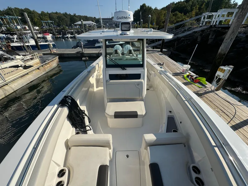 Slide: The Image of 2023 Sailfish 312 CC boat docked at marina, featuring spacious seating and Garmin equipment. - 15