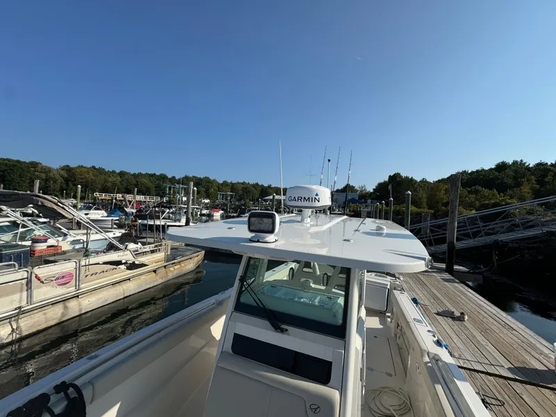 Slide: The Image of 2023 Sailfish 312 CC boat docked at marina under clear blue sky. - 18