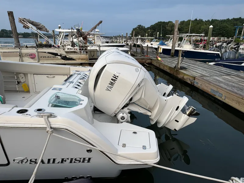Slide: The Image of 2023 Sailfish 312 CC boat with Yamaha outboard motor docked at marina. - 2