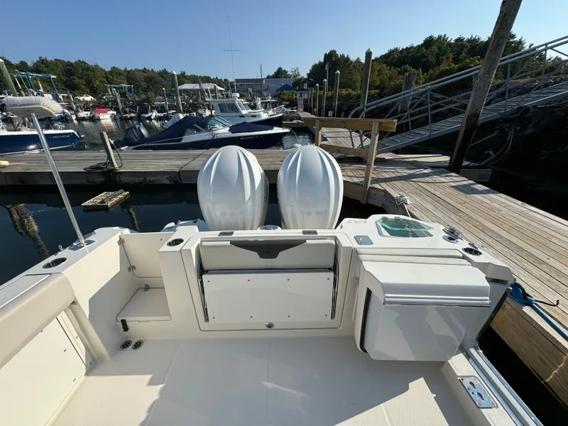Slide: The Image of 2023 Sailfish 312 CC boat docked, featuring dual outboard motors and spacious deck area. - 4