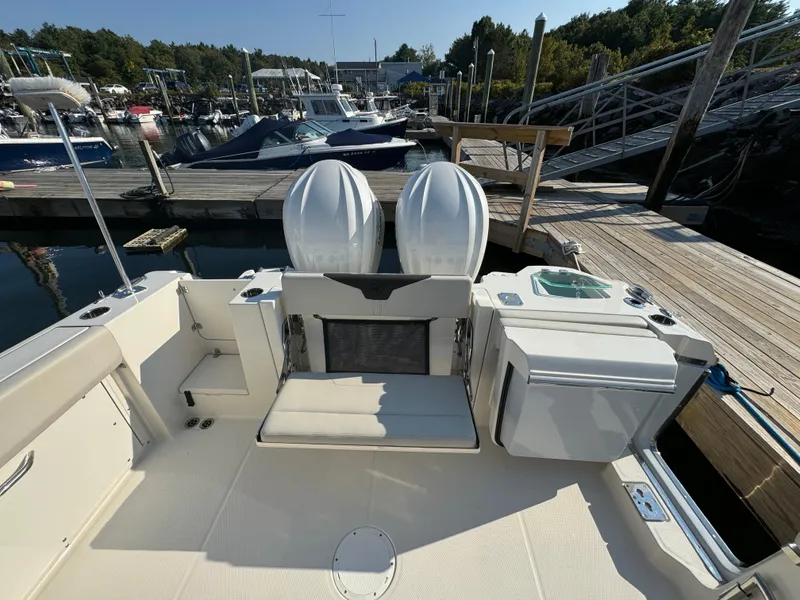 Slide: The Image of 2023 Sailfish 312 CC boat docked, featuring dual engines and spacious deck area. - 5