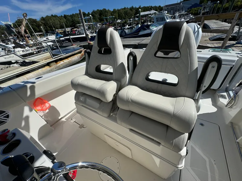 Slide: The Image of 2023 Sailfish 312 CC boat with dual cushioned seats at a marina. - 7