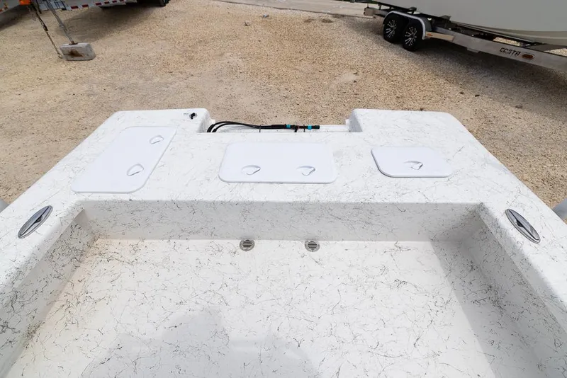 Slide: The Image of 2026 Coastal Skiff 231 boat deck with storage compartments and textured surface. - 13