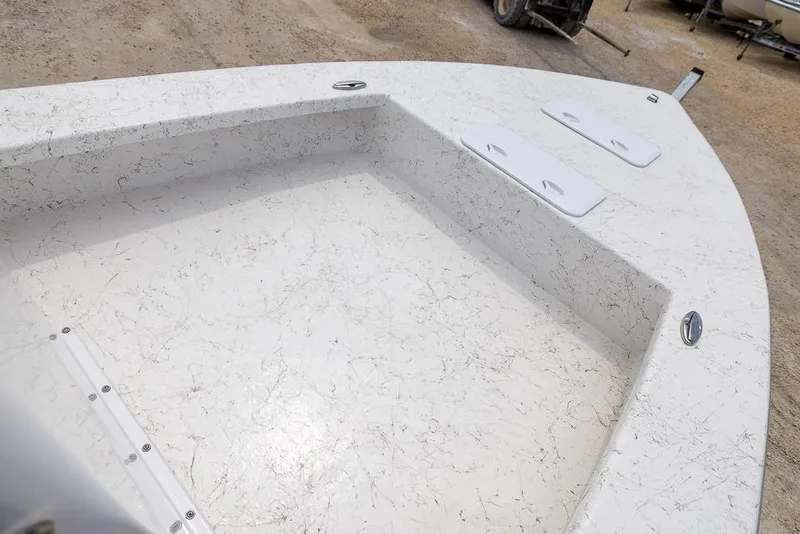 Slide: The Image of 2026 Coastal Skiff 231 boat deck with textured surface and storage compartments. - 17