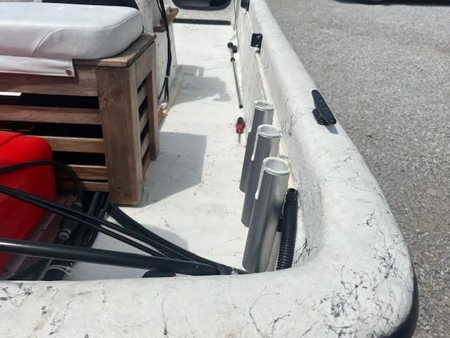 Slide: The Image of 2000 Carolina Skiff J1450 interior with rod holders and seating, showcasing fishing setup. - 3