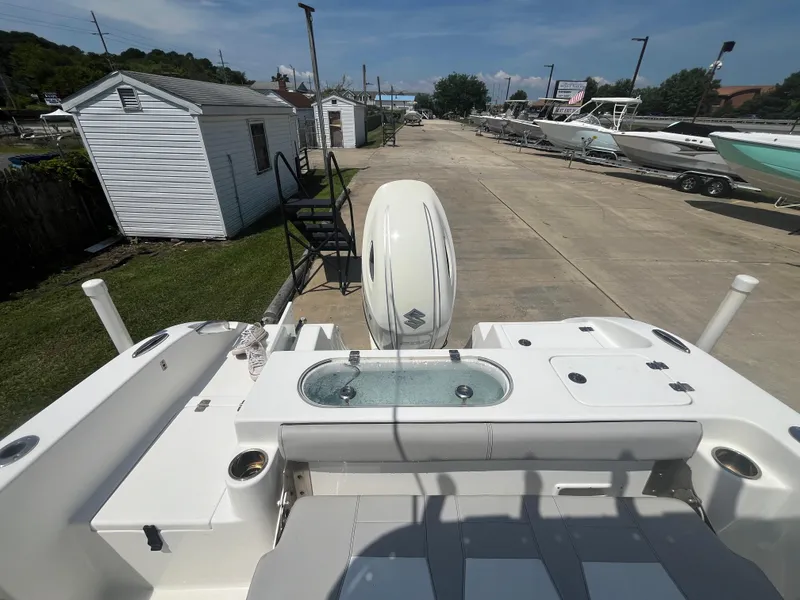 Slide: The Image of 2018 Sea Pro 219 Center Console boat with outboard motor, docked near storage sheds. - 14