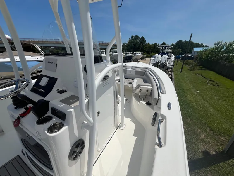 Slide: The Image of 2018 Sea Pro 219 Center Console boat with white interior and control panel, docked outdoors. - 15