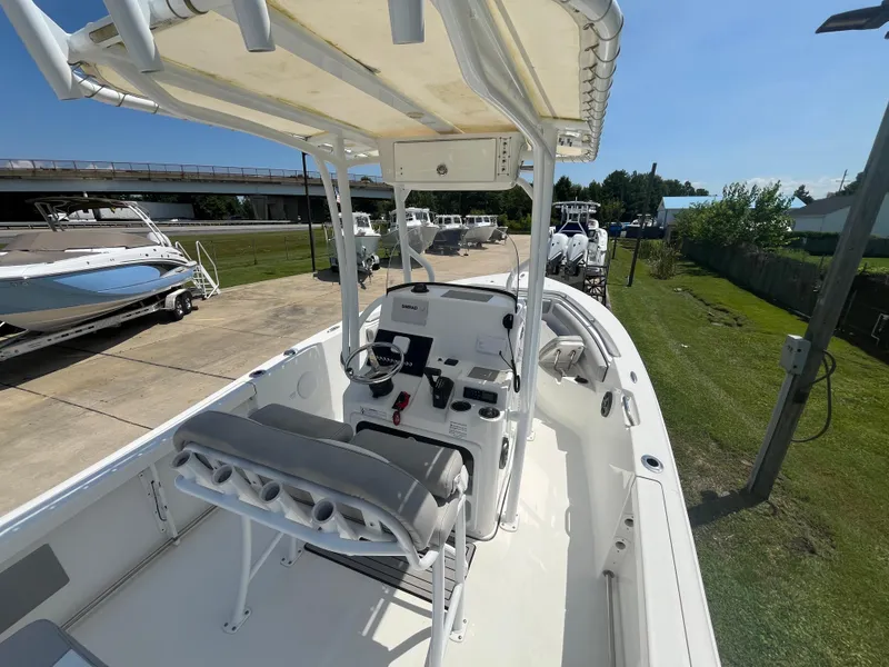 Slide: The Image of 2018 Sea Pro 219 Center Console boat with helm, seating, and canopy in outdoor setting. - 16