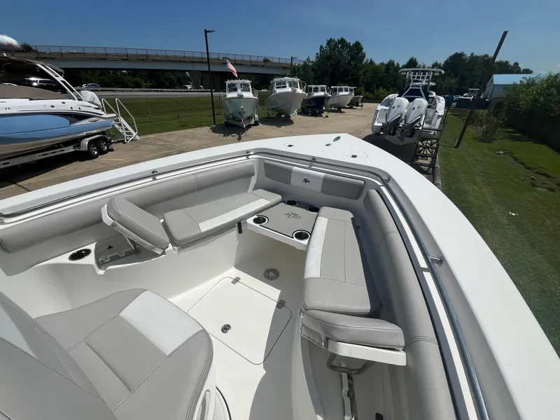 Slide: The Image of 2018 Sea Pro 219 Center Console boat with spacious seating and cup holders, docked outdoors. - 8