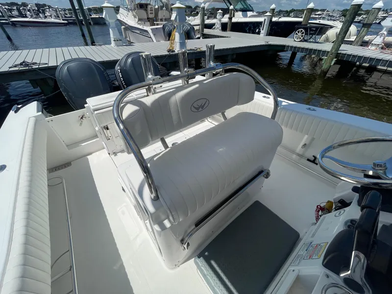Slide: The Image of 2006 Southport 26 Center Console boat interior with seating and steering wheel at marina. - 16