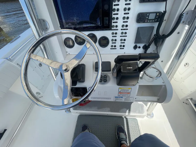 Slide: The Image of 2006 Southport 26 Center Console boat dashboard with steering wheel and controls. - 19