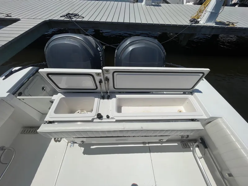 Slide: The Image of 2006 Southport 26 Center Console boat with open storage compartments and dual engines at dock. - 35