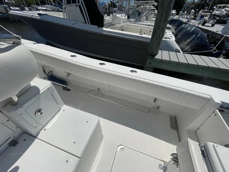 Slide: The Image of 2006 Southport 26 Center Console boat interior with white seating and storage compartments. - 36