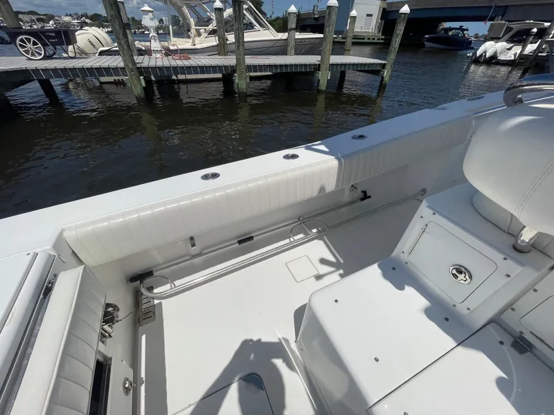 Slide: The Image of 2006 Southport 26 Center Console boat interior near dock, showcasing seating and storage. - 37