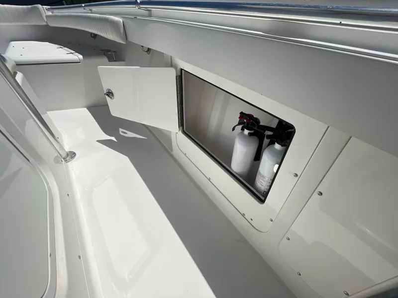 Slide: The Image of 2006 Southport 26 Center Console boat interior with open storage compartment and fire extinguishers. - 40