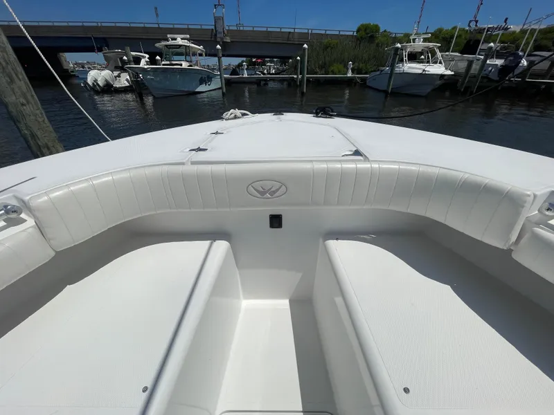 Slide: The Image of 2006 Southport 26 Center Console boat interior with white seating, docked near other boats. - 5