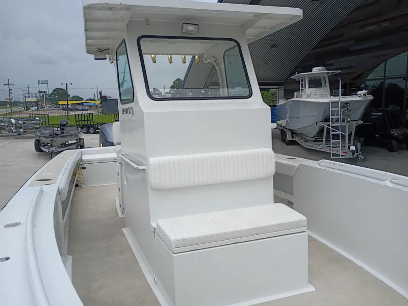 Slide: The Image of Custom 32CC 2005 boat with white cabin and seating, docked outdoors. - 14