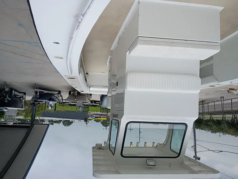Slide: The Image of Upside-down view of a 2005 Custom 32CC boat docked near a marina. - 15